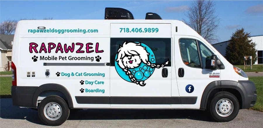 White van with "RAPAWZEL Mobile Pet Grooming" branding, contact info, and cartoon dog logo, advertising mobile dog grooming, daycare, and pet boarding services.